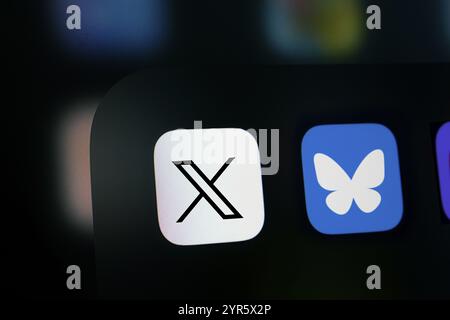 Nahaufnahme eines iPhone-Bildschirms mit dem X (twitter) App-Symbol und dem Bluesky App-Symbol Stockfoto