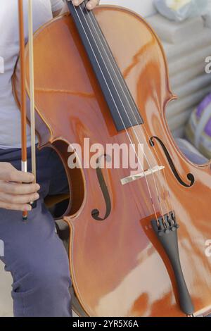 Nahaufnahme der Hände eines nicht erkennbaren Mannes, die Cello spielen Stockfoto