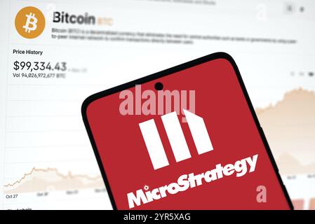 Das microstrategy-Logo wird auf dem Smartphone und der Bitcoin-Preis im Hintergrund angezeigt. Stockfoto