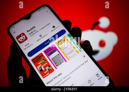 SEATTLE, WA, USA – 3. April 2025: Ein Mann hält Smartphone mit Reddit-App auf Google Play. Reddit ist ein US-amerikanisches Social-News-Aggregat. Stockfoto