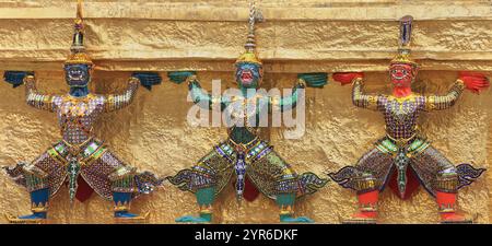 Yaksha Dämon Statuen mit dem goldenen Chedi im Tempel des Smaragd Buddha, Grand Palace, Bangkok, Thailand Stockfoto