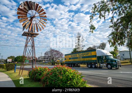 Truck vorbei an einer großen Windmühle vor dem Touristeninformationszentrum am Burnett Highway, Goomeri, Queensland Australien Stockfoto