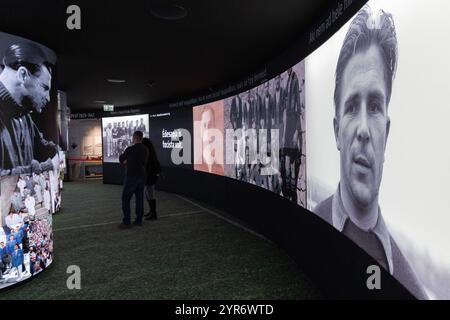 Budapest, ungarischer Fußballspieler Ferenc Puskas. November 2024. Eine Videoinstallation mit mehreren Bildschirmen spielt Ferenc Puskas' Karrieremomente im neu eröffneten Puskas Museum in Budapest, Ungarn am 30. November 2024. Das Puskas-Museum, benannt nach dem ehemaligen ungarischen Fußballspieler Ferenc Puskas, wurde am 15. November 2024 in Budapest eröffnet. Quelle: Attila Volgyi/Xinhua/Alamy Live News Stockfoto