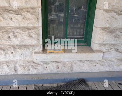 Georgetown, Texas, USA. November 2024. Auf einer Fensterbank des historischen Gefängnisses Williamson County in Georgetown, Texas, befindet sich eine Bibel, als Bauleute am 29. November 2024 Teile des Gebäudes abreißen. Das Hauptgebäude wird nicht abgerissen, da es als Texas Historic Landmark geschützt und im National Register of Historic Places eingetragen ist. Seit 1848 befindet sich ein Gefängnis auf dem Gelände, das heutige Kalksteingebäude im französischen Bastille-Stil wurde 1888 eröffnet, um das ursprüngliche Gebäude zu ersetzen und blieb bis 1989 in Betrieb. (Bild: © Scott Coleman/ZUMA Press Wi Stockfoto