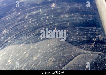 Verschmierte und schmutzige Frontscheibe eines Fahrzeugs nach dem Auftreffen von Insekten. Stockfoto