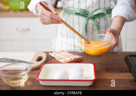 Frau löst Eierflüssigkeit mit Essstäbchen Stockfoto