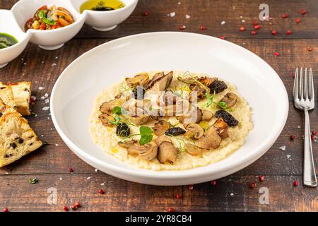 Stachelpilz-Risotto auf einer weißen Porzellanplatte, Risotto Ai funghi Stachelpilz Stockfoto