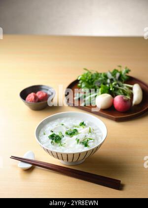 Reisbrei mit sieben Kräutern und eingelegten Pflaumen Stockfoto