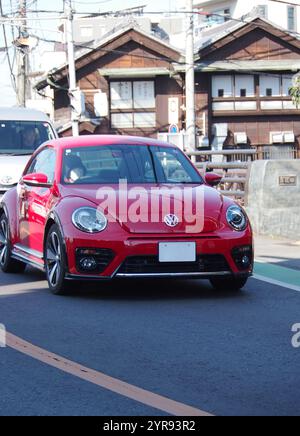 Ein roter, deutscher Volkswagen New Beetle fährt auf den Straßen der Stadt Stockfoto