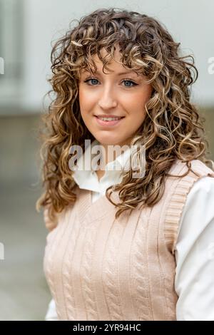 Selbstbewusste junge Geschäftsfrau lächelt, zeigt Professionalität und offenes Auftreten im Geschäftsumfeld Stockfoto