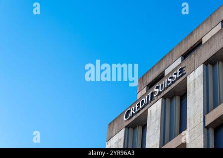 Zeichen und Logo auf einem Gebäude der Credit Suisse Group AG, einer ehemaligen Schweizer Bankengruppe, die 2023 erworben und mit UBS fusioniert wurde. Negativer Raum Stockfoto