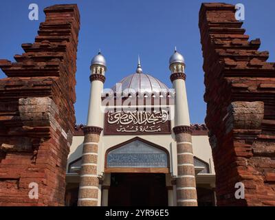 Vorderansicht der Moschee mit arabischer Kalligraphie, die ihren Namen aussagt: Al-Aqso-Moschee, Kudus-Turm. Akkulturation arabischer und hinduistischer Architektur Stockfoto