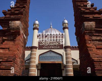 Vorderansicht der Moschee mit arabischer Kalligraphie, die ihren Namen aussagt: Al-Aqso-Moschee, Kudus-Turm. Akkulturation arabischer und hinduistischer Architektur Stockfoto