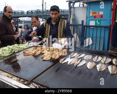 Türkischer Mann verkauft frittierten Fisch an Touristen in Eminonu in Istanbul. Essen auf der Straße ist ein Teil des lokalen Lebens hier. Stockfoto