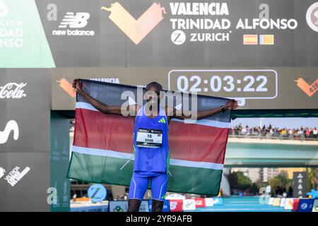 Der Sieger des Valencia-Marathons 2024, Kenian Sebastian Sawe, feiert den Sieg mit der Flagge seines Landes Kenia. Valencia, 1. Dezember 2024 Stockfoto