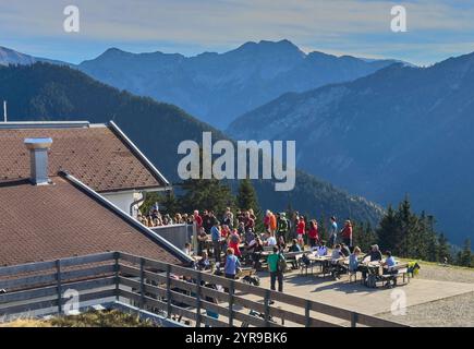 Wanderer, Touristen und Wanderer mit Hunden auf der Dürrenberg Alm mit Blick auf das Lechtal mit dem Lech und dem Hahnenkamm in Reutte, Österreich am 1. November 2024 Stockfoto