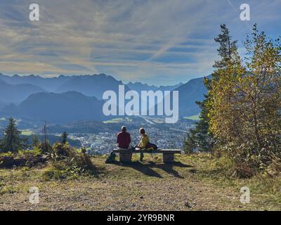 Wanderer, Touristen und Wanderer mit Hunden auf der Dürrenberg Alm mit Blick auf das Lechtal mit dem Lech und dem Hahnenkamm in Reutte, Österreich am 1. November 2024 Stockfoto