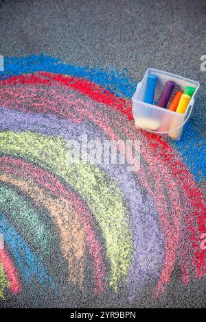 Kreidezeichnung auf dem Gehweg. Ein Regenbogen auf dem Asphalt. Aktivitäten für Kinder. Farbige Kreide im Hintergrund. Zurück zur Schule Stockfoto