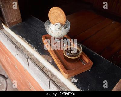 Eine Portion Affogato-Kaffee mit einem Glas Eis und Keksen, serviert in einem Café-Fenster Stockfoto