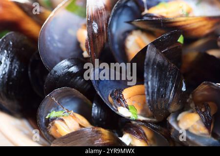 Gekochte Muscheln in Schüssel auf hölzernem Hintergrund aus nächster Nähe Stockfoto