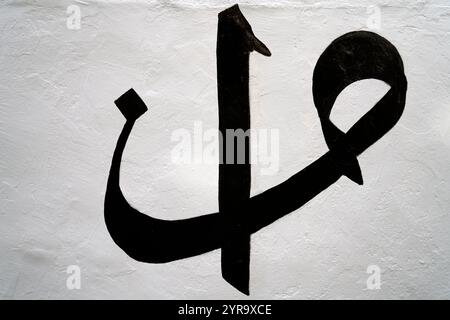 Die Buchstaben „vav“ und „alif“ des arabischen Alphabets, geschrieben an der Wand. Stockfoto