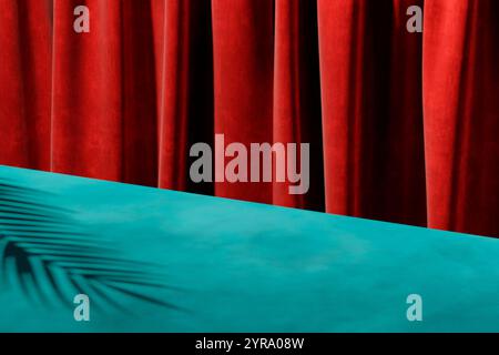 Moderner Farbhintergrund mit Palmenschatten auf blauem Tisch mit rotem Hintergrund. Trendige farbenfrohe Studioszene für luxuriöse Produktpräsentationen. Stockfoto