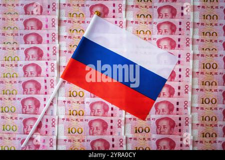 Die russische Flagge und der chinesische Yuan. Der Geldumsatz des Yuan in Russland ist ein Konzept. Stockfoto