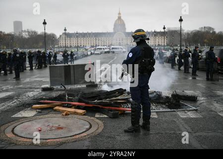 Paris, Frankreich. Dezember 2024. Ein Polizeibeamter beobachtet, wie Taxifahrer an einer Demonstration während eines Streiks in Paris am 3. Dezember 2024 teilnehmen. Foto: Firas Abdullah/ABACAPRESS. COM Credit: Abaca Press/Alamy Live News Stockfoto