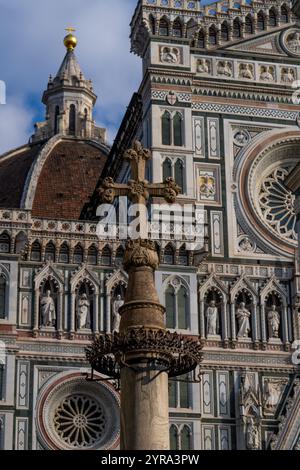 Ein gemeißeltes Steinkreuz auf einer Säule vor dem Dom in Florenz, Italien. Stockfoto