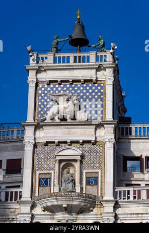 Detail des Markusturms auf dem Markusplatz in Venedig, Italien, mit dem Löwen von St. Markus und Mauren, die die Glocke läuten. Stockfoto