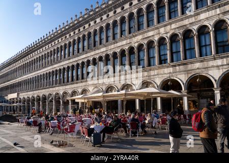 Gäste speisen im Freien vor der Procuratie Vecchie auf dem Markusplatz in Venedig, Italien. Stockfoto
