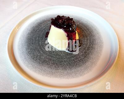 Ein traditionelles Panna Cotta Dessert mit einer gemischten Beerensoße in einem Restaurant in Venedig, Italien. Stockfoto