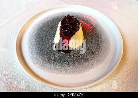 Ein traditionelles Panna Cotta Dessert mit einer gemischten Beerensoße in einem Restaurant in Venedig, Italien. Stockfoto