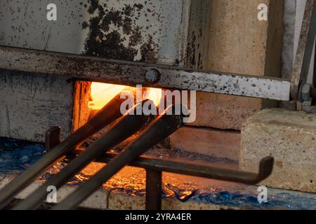 Blaspfeifen und ein Ofen in einem Glasbläserstudio in Venedig, Italien. Stockfoto