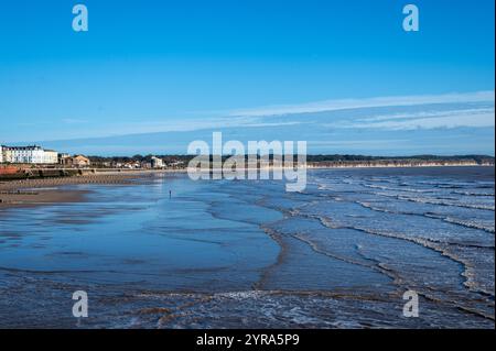 Helle Oktobersonne über Bridlington Beach, East Yorkshire, eine ruhige Küstenszene mit klarem blauen Himmel, Sandstrand und Promenade Stockfoto