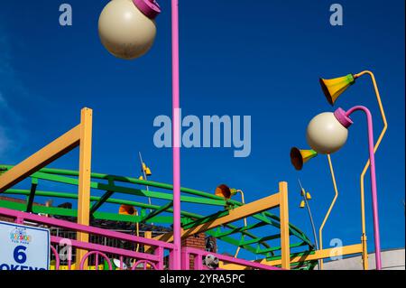 Farbenfrohe Fahrt auf dem Festgelände im Bayside Fun Park an der Küste von Bridlington, an einem sonnigen Oktobertag vor einem klaren blauen Himmel. Stockfoto