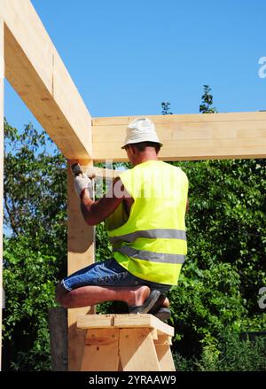 Dachdecker verbinden Holzbalken von Hausdachkonstruktionen. Stockfoto