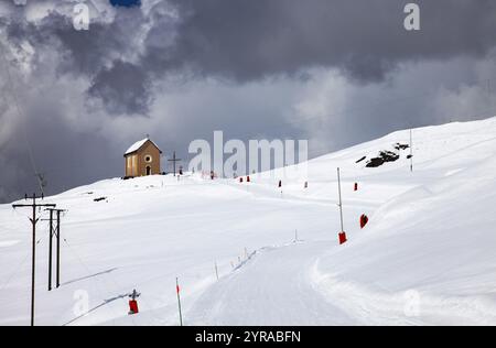 Saint-Véran (Südostfrankreich): Das Dorf nach einem sehr starken Schneefall. Skifahrer auf den Pisten am Fuße der Kapelle Sainte-Marie-Madelein Stockfoto