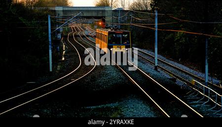 Whitley Bay Tyne und Wear Metro fahren am späten Nachmittag auf verwinkelten goldenen Eisenbahnlinien Stockfoto
