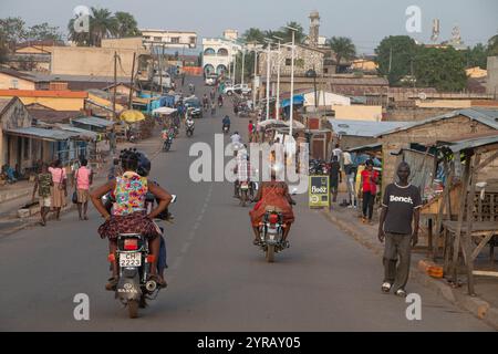 Geschäftige Urban Street in Togo mit Motorrädern, Fußgängern und lokalen Geschäften, die das tägliche afrikanische Leben darstellen Stockfoto