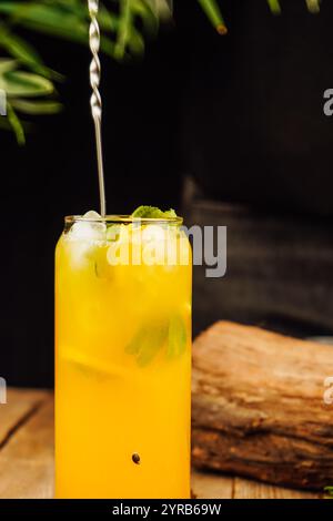 Martini-Cocktail mit Passionsfrucht. Saures alkoholisches Getränk mit frischer Passionsfrucht und Limette, mit einem Strohhalm im Glas. Stockfoto