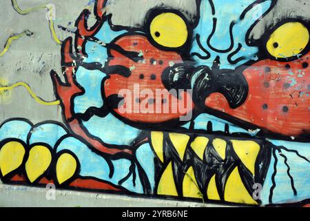 Wunderschöne, lebendige Zeichnungen und Tierbilder auf einer bräunlich-grauen Betonwand. Graffiti, ein großer Kopf, die Mündung eines Tigers mit Blau, Grau. Stockfoto