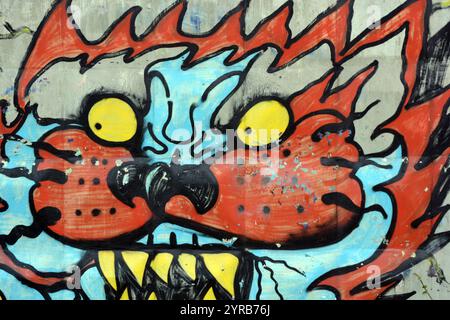 Wunderschöne, lebendige Zeichnungen und Tierbilder auf einer bräunlich-grauen Betonwand. Graffiti, ein großer Kopf, die Mündung eines Tigers mit Blau, Grau. Stockfoto