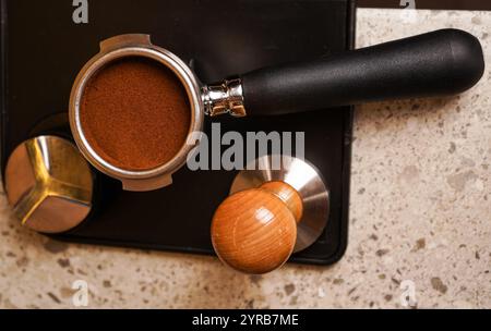 Nahaufnahme des manuellen Cafés Barista, das Kaffee von Hand zubereitet und gemahlenen Kaffee mithilfe von Stamping in einem Café presst. Stockfoto