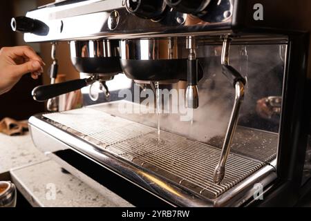 Ein Barista arbeitet am Schalter in einem Café und bereitet sich auf die Zubereitung von Kaffee vor. Kaffee in einem Café zubereiten. Stockfoto