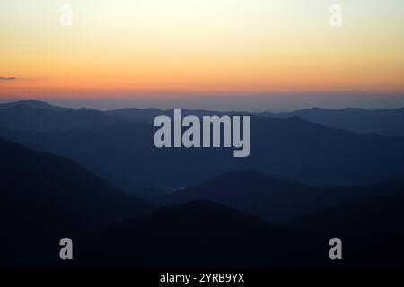 Silhouette einer Bergkette mit einem roten Sonnenuntergang im Hintergrund Stockfoto