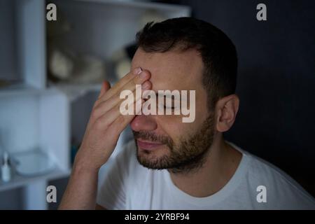 Der 30-jährige Mann trägt Feuchtigkeitscreme auf sein Gesicht auf Stockfoto