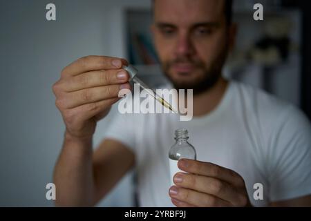 Ein 30-jähriger Mann wendet ein Bartwuchsprodukt an Stockfoto