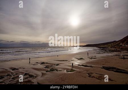 Zerstreute Menschen, die auf Scarborough Sands in England laufen. Stockfoto