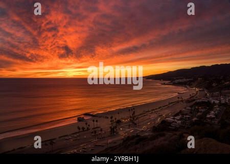 10. JANUAR 2022, PACIFIC PALISADES, LOS ANGELES, USA - Sonnenuntergang an der Santa Monica Bay in Richtung Malibu vom Pacific Palisades Bluff Park zeigt den Verkehr auf der Route 1 Pacific Coast Highway Stockfoto